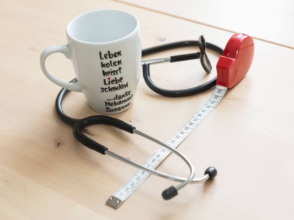 Tasse mit Aufschrift, Stethoskop und Maßband Tasse mit Aufschrift, Stethoskop und Maßband